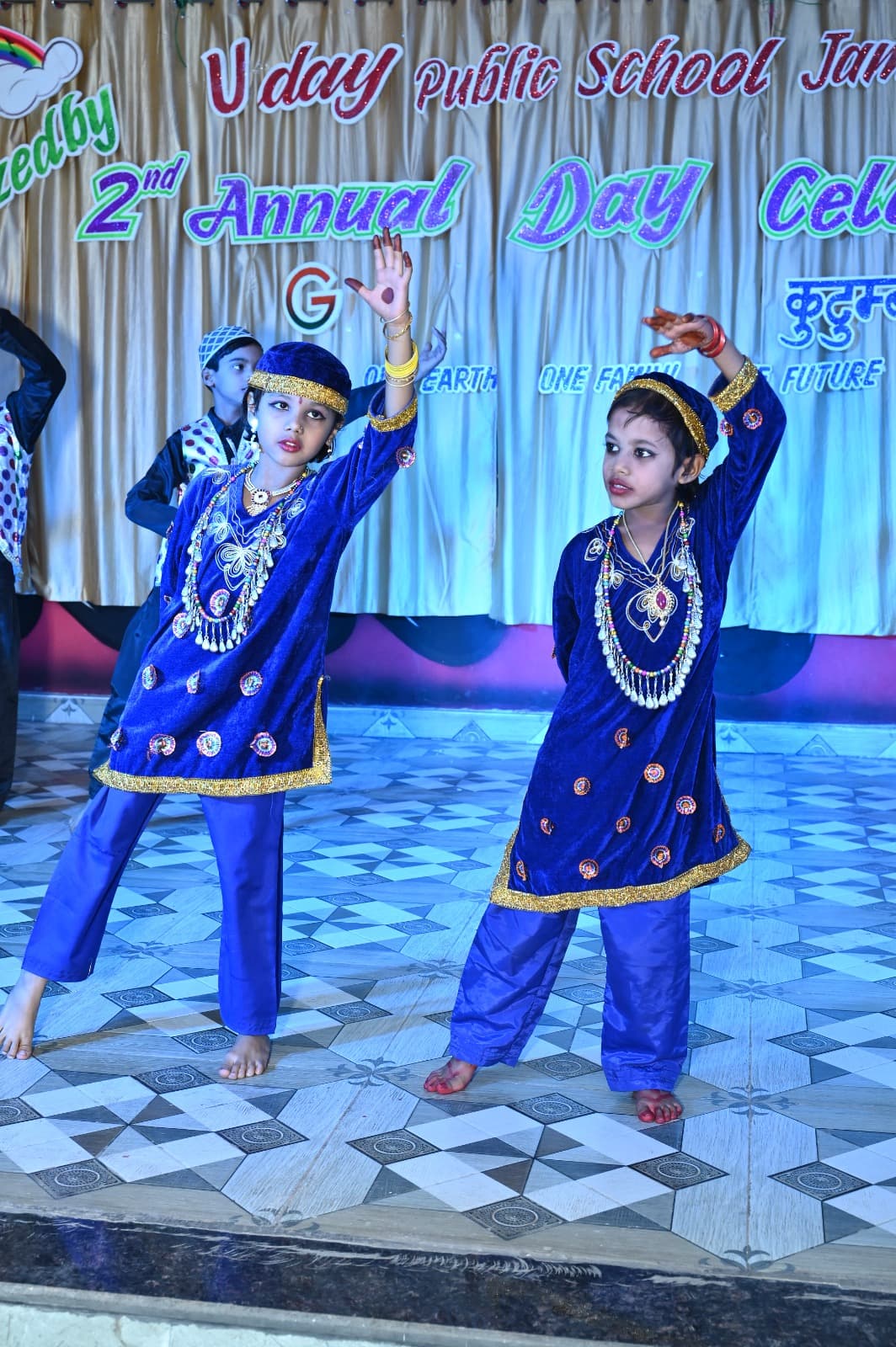 Two students dancing in blue costumes
