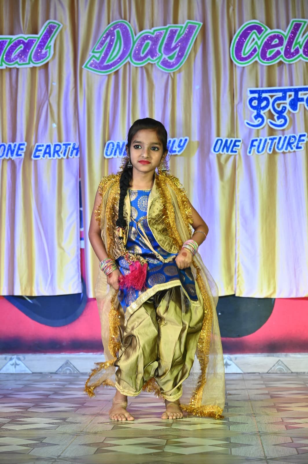 A student performing a solo dance in a golden costume